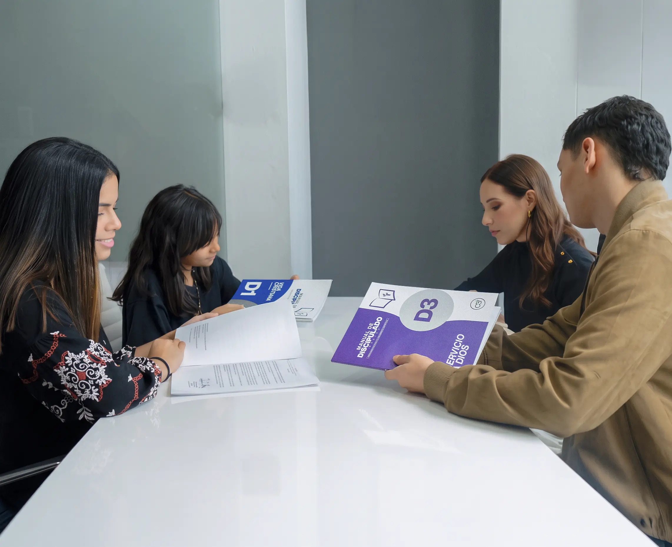 Un grupo repasa los cuadernillos del discipulado alrededor de una mesa