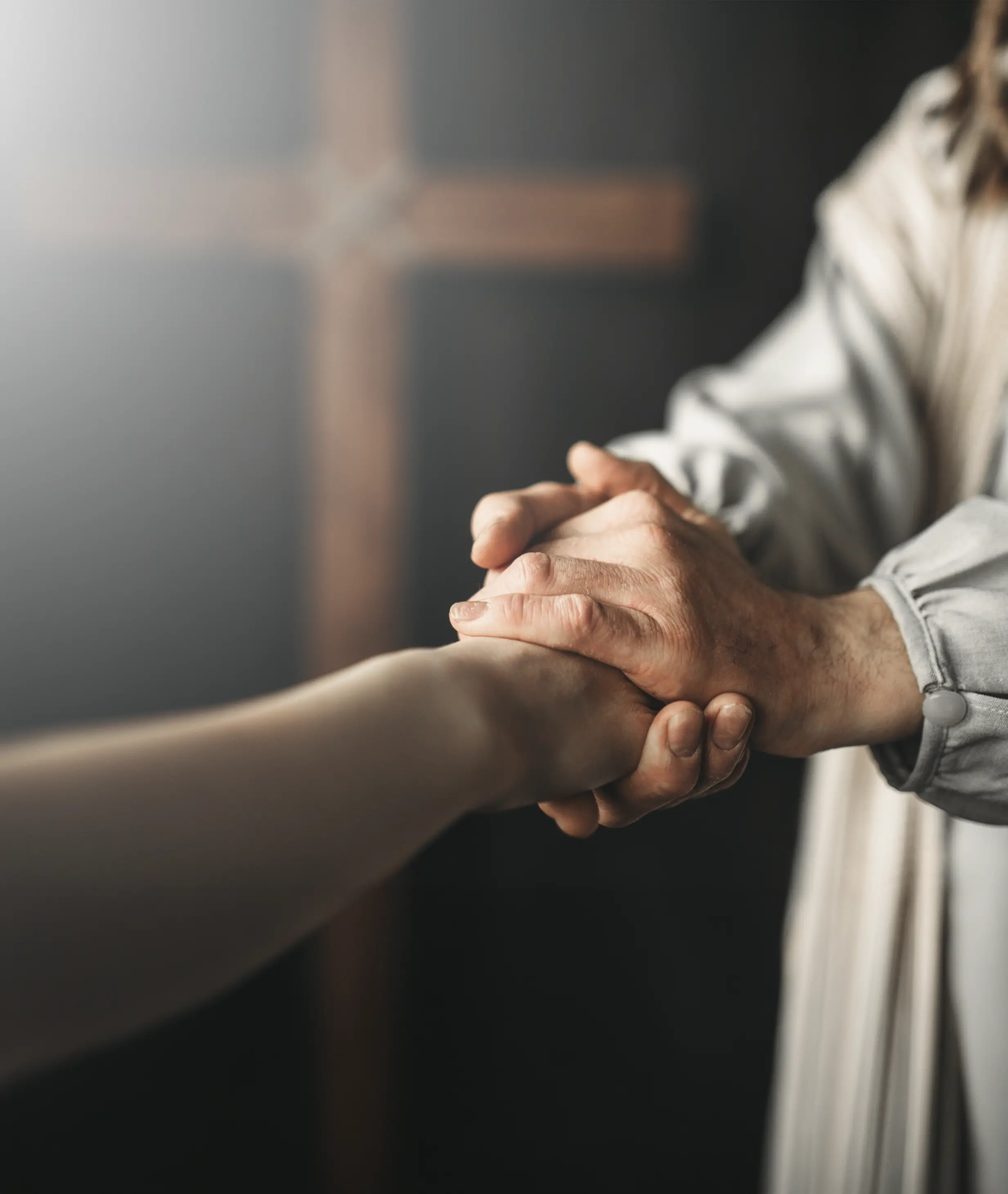 Manos unidas en oración sobre una Biblia abierta